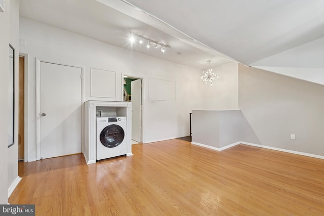 1029 Spruce St Unit 304, Philadelphia, PA 19107 - laundry room with a chandelier, laundry area, washer / dryer, and light wood-style flooring