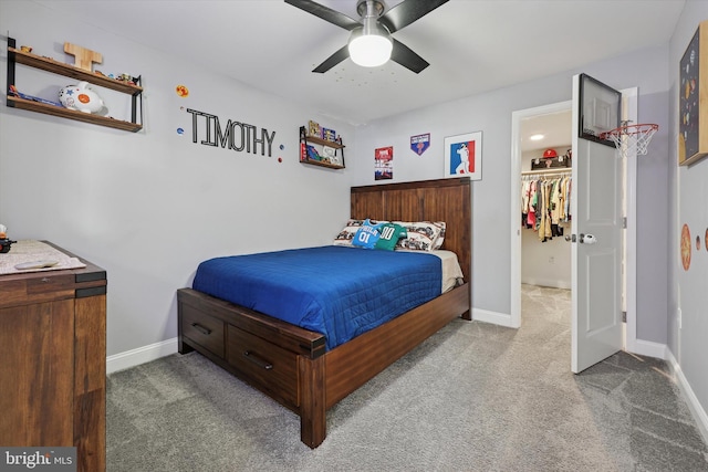 bedroom featuring carpet, ceiling fan, a spacious closet, and baseboards