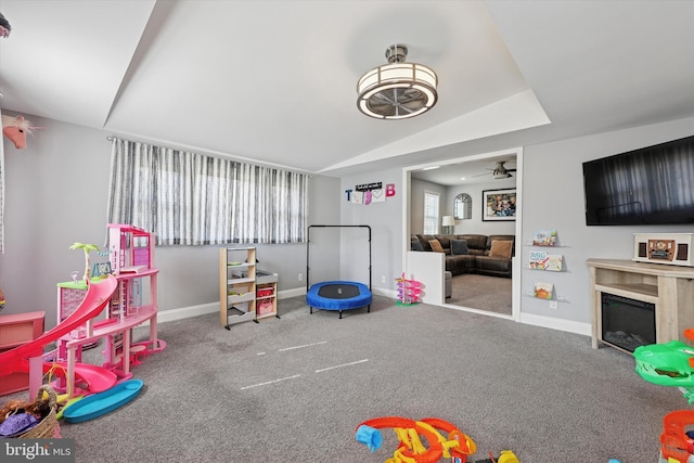 rec room with carpet, baseboards, vaulted ceiling, and a glass covered fireplace