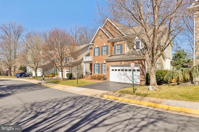 view of front facade featuring driveway, a balcony, a front yard, a garage, and brick siding