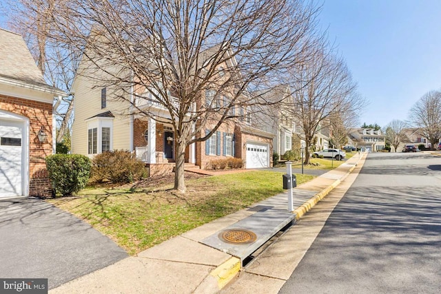 view of front facade with a garage, brick siding, and aphalt driveway