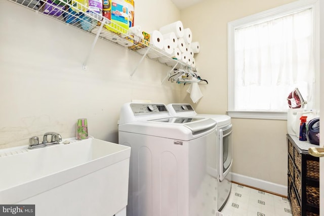 laundry room with washer and clothes dryer, laundry area, a wealth of natural light, and a sink