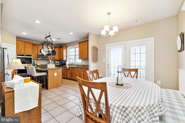 dining space with light tile patterned floors, recessed lighting, and a chandelier