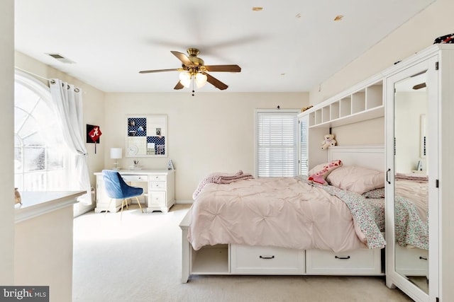 bedroom featuring a ceiling fan, light colored carpet, and visible vents