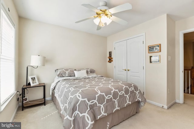 carpeted bedroom featuring a closet, a ceiling fan, and baseboards