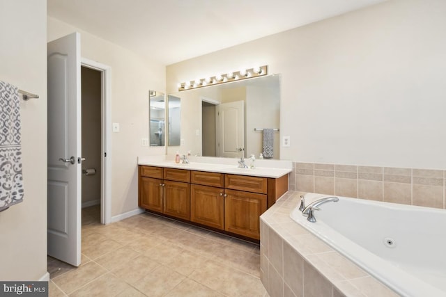 bathroom featuring tile patterned flooring, baseboards, double vanity, a tub with jets, and a sink