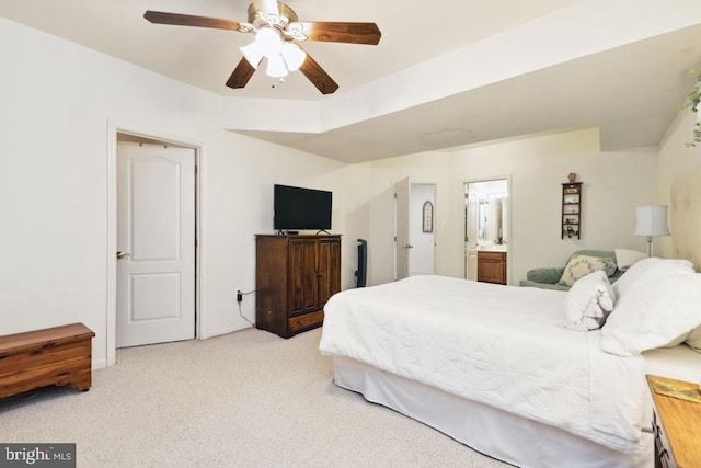 bedroom featuring light carpet, connected bathroom, and ceiling fan