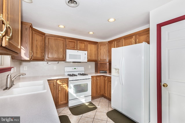 kitchen featuring white appliances, light tile patterned floors, visible vents, a sink, and light countertops