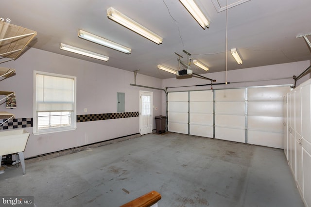 garage with electric panel and a garage door opener