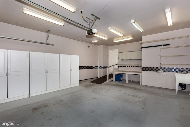 garage with a garage door opener and a sink