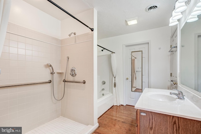 bathroom featuring vanity, bathing tub / shower combination, wood finished floors, and visible vents