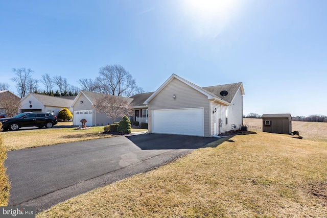 ranch-style home with aphalt driveway, a garage, and a front lawn