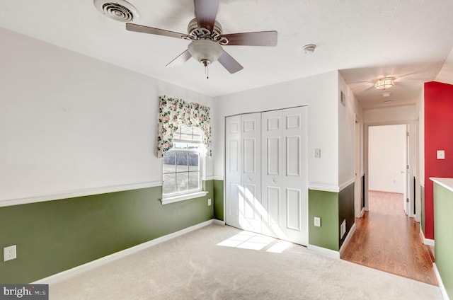 unfurnished bedroom featuring baseboards, visible vents, carpet floors, and a closet