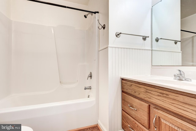 full bathroom with wainscoting, vanity, and shower / bathtub combination