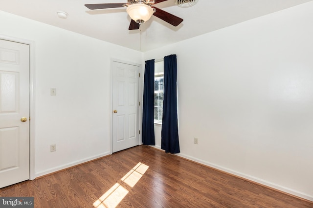 unfurnished bedroom featuring baseboards, wood finished floors, and a ceiling fan