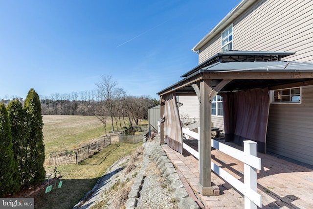 view of yard with a rural view, an outbuilding, and fence