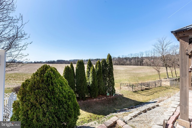 view of yard with a rural view and fence