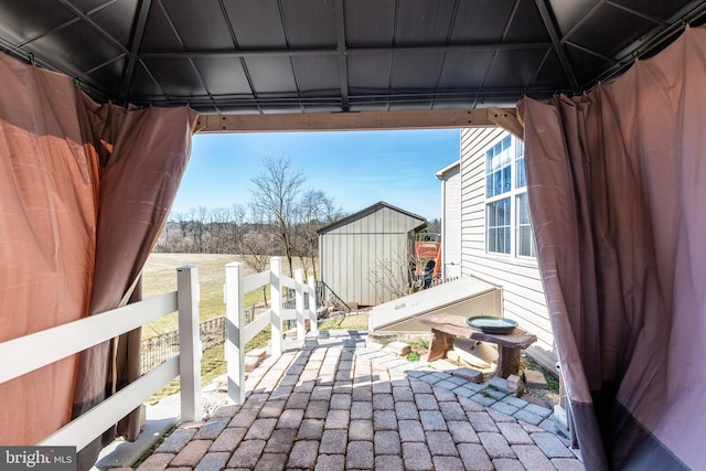 view of patio / terrace with a storage shed, an outdoor structure, and fence