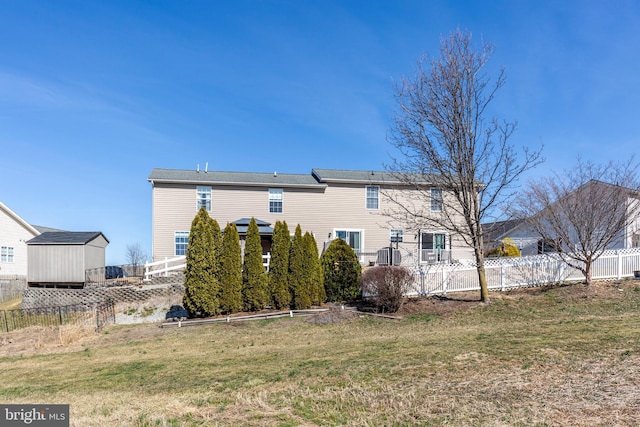 rear view of house with a lawn and a fenced backyard