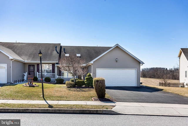 view of front of home with a garage, driveway, a porch, and a front yard