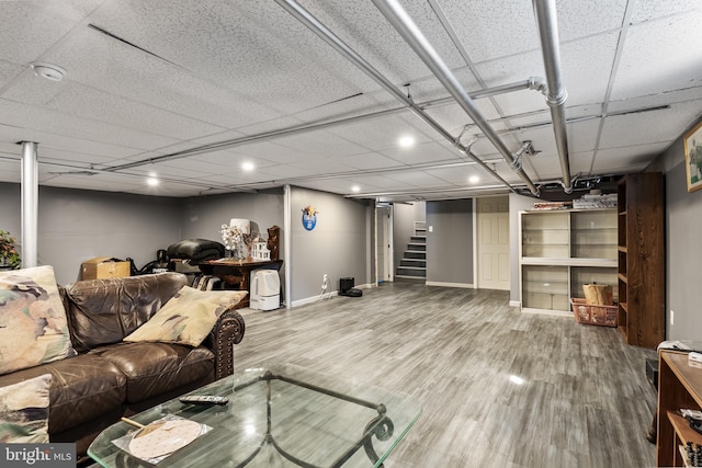 living area featuring baseboards, stairway, and wood finished floors