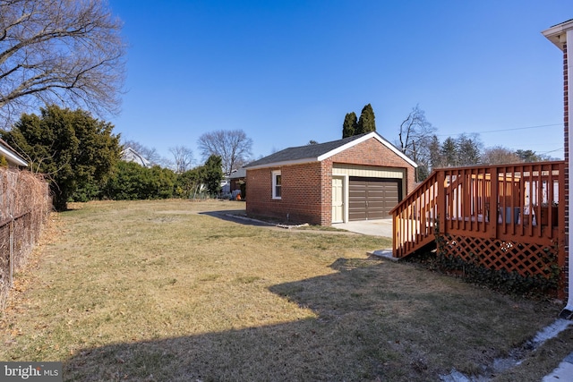 view of yard with a deck, an outdoor structure, and a detached garage