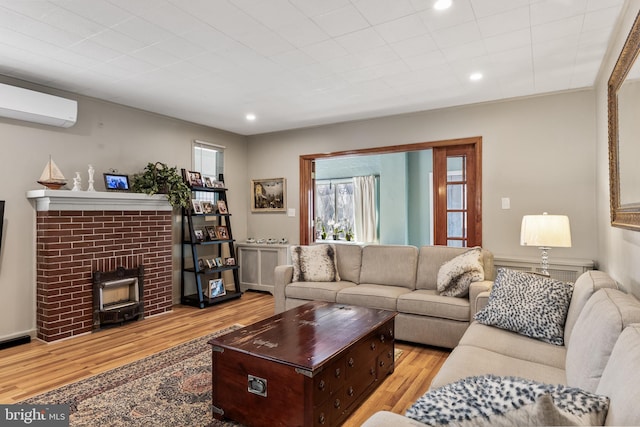 living room featuring recessed lighting, a wood stove, a wall mounted air conditioner, and wood finished floors