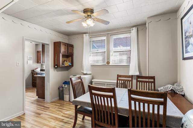 dining space featuring ceiling fan, baseboards, and light wood-style floors