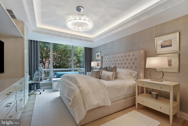 bedroom featuring a chandelier, a tray ceiling, visible vents, and wallpapered walls