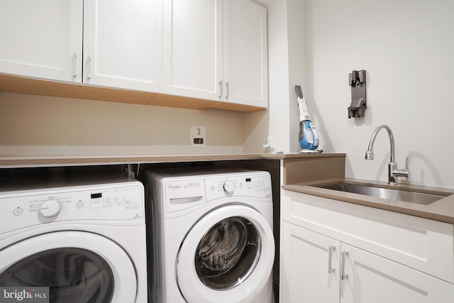 laundry room with cabinet space, a sink, and separate washer and dryer