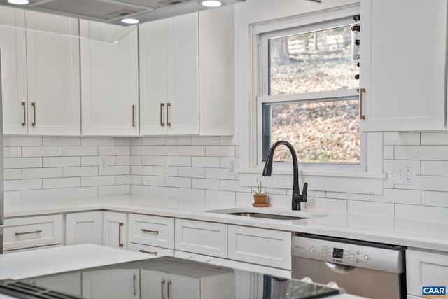 kitchen featuring dishwasher, light countertops, a sink, and white cabinetry