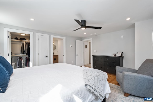 bedroom with recessed lighting, a walk in closet, ceiling fan, and wood finished floors