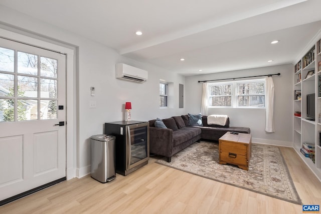 living room with recessed lighting, a wall unit AC, and light wood-style floors