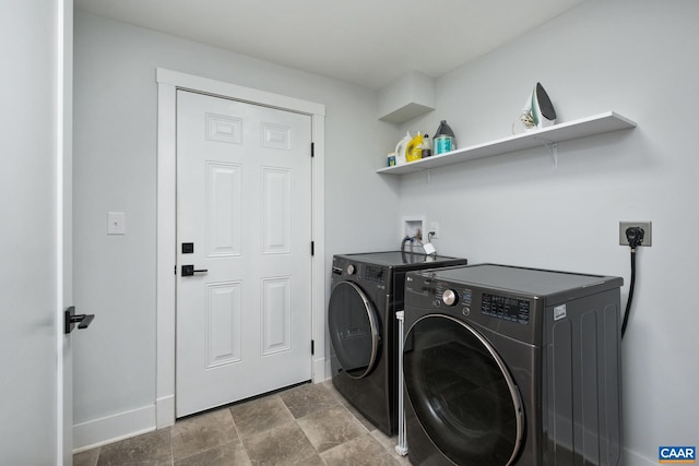 laundry area featuring laundry area, washer and clothes dryer, stone finish floor, and baseboards