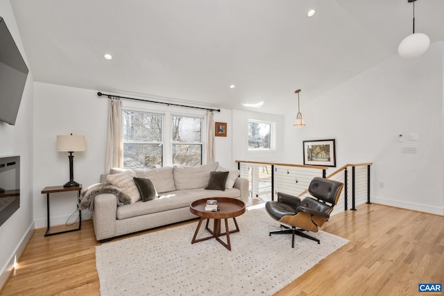 living area featuring recessed lighting, baseboards, vaulted ceiling, and light wood finished floors