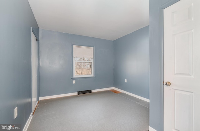 spare room featuring baseboards and carpet