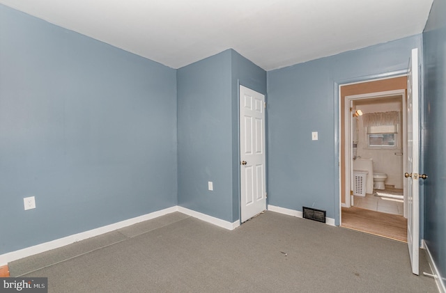 unfurnished bedroom featuring baseboards, visible vents, and carpet floors