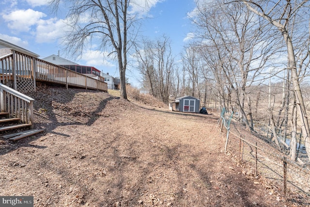 view of yard featuring a wooden deck, an outbuilding, a storage shed, and stairway