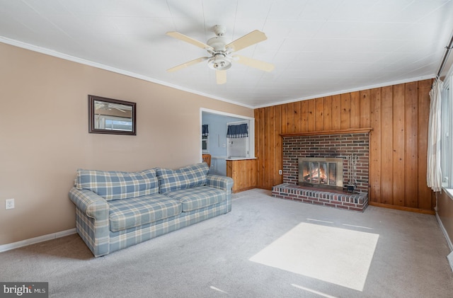 living area with a ceiling fan, carpet, a fireplace, ornamental molding, and wood walls