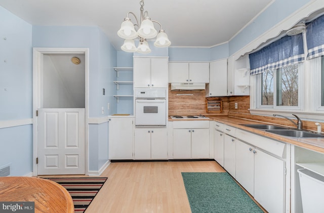 kitchen with open shelves, a sink, oven, white cabinets, and under cabinet range hood