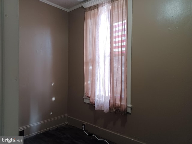 empty room with ornamental molding and baseboards