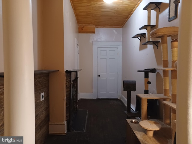 hall featuring crown molding, wood ceiling, and baseboards