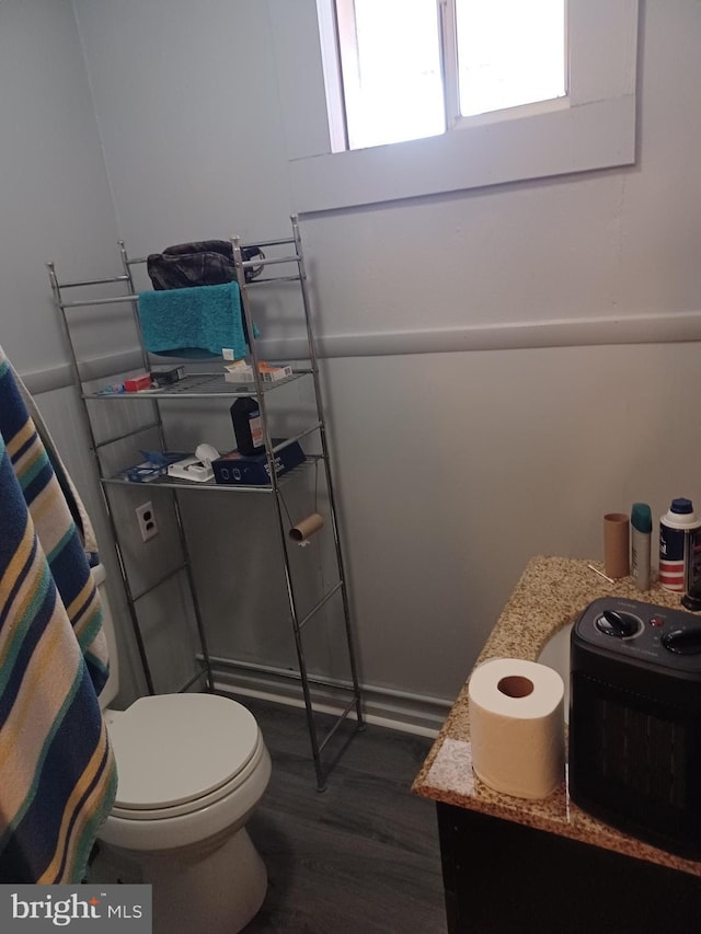 bathroom with wood finished floors and toilet