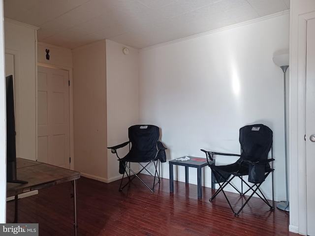 sitting room featuring ornamental molding, wood finished floors, and baseboards