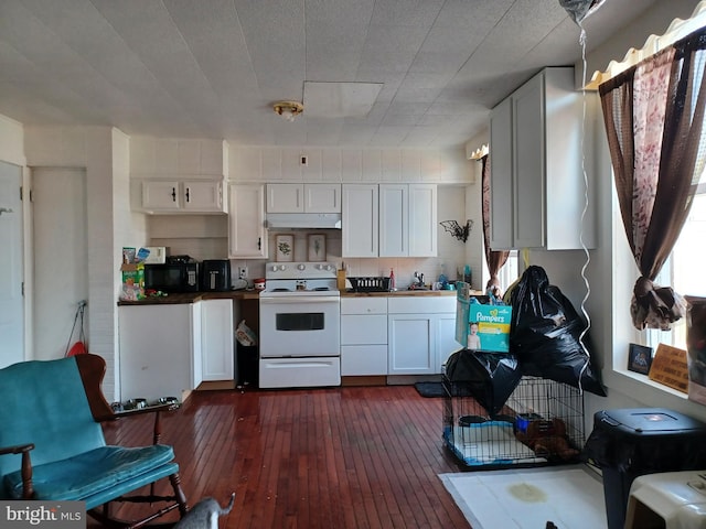 kitchen with black microwave, under cabinet range hood, electric range, dark wood-type flooring, and white cabinetry