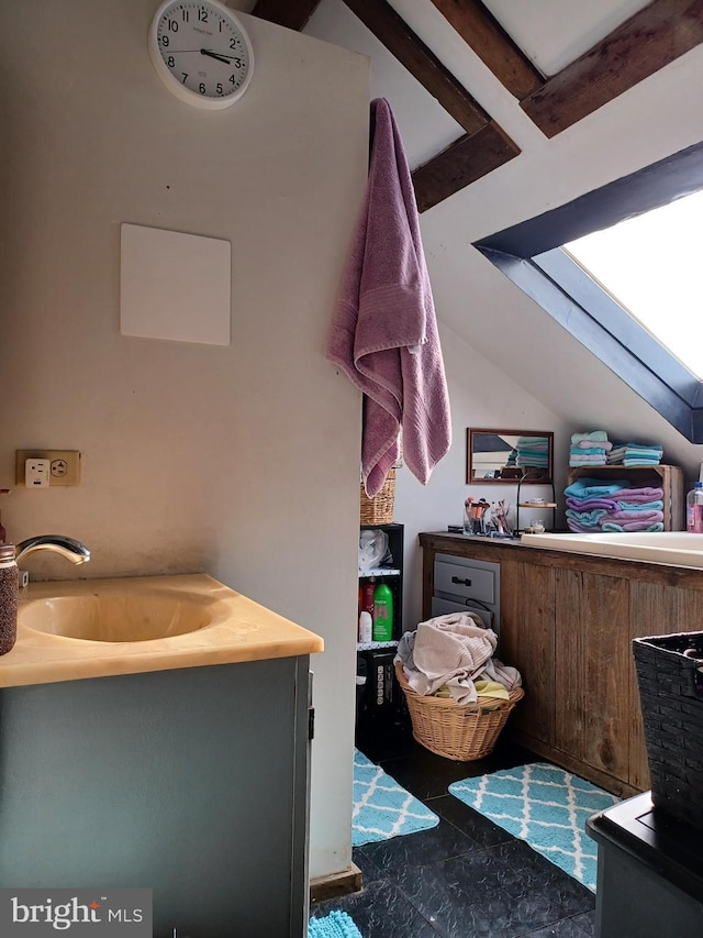 bathroom featuring lofted ceiling and a sink