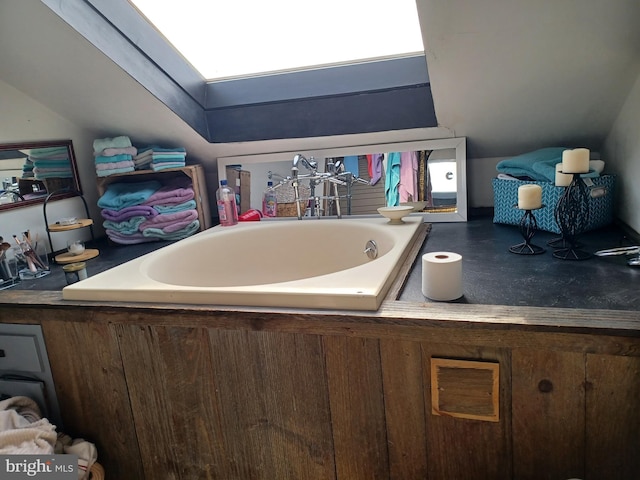 bathroom featuring vaulted ceiling with skylight