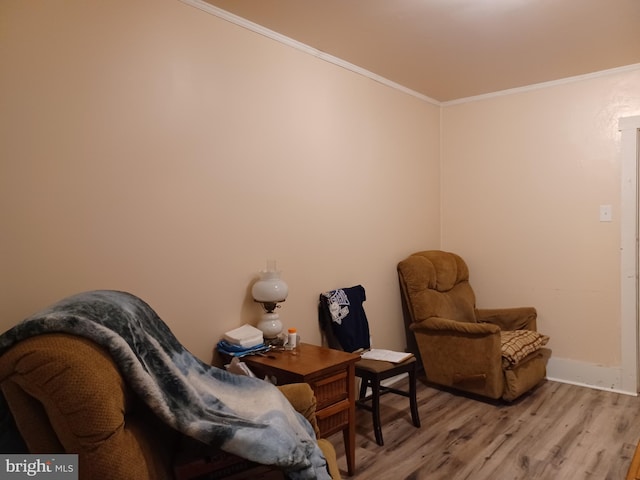 sitting room featuring crown molding and light wood finished floors