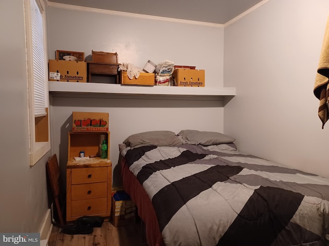 bedroom featuring ornamental molding and wood finished floors