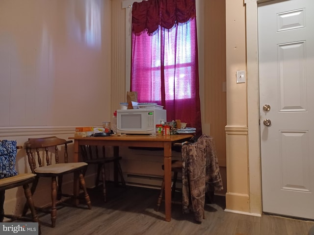 office space featuring a wealth of natural light, a baseboard radiator, and wood finished floors